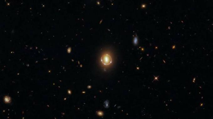 Au centre de cette image se trouvent six points de lumière brillants, quatre d'entre eux créant un cercle autour d'une paire centrale. Il ne s’agit pas de deux galaxies distinctes et d’un quasar distant photographié quatre fois.