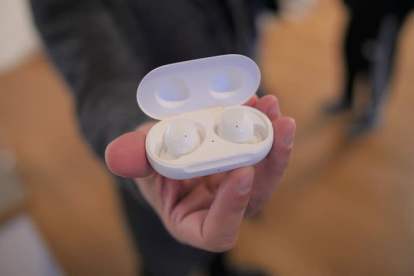 En person som håller i Samsung Galaxy Buds 2 i ett fodral.