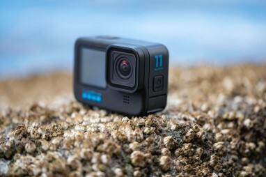 GoPro Hero 11 Black على صخرة بها حيوانات البرنقيل بجوار المحيط.