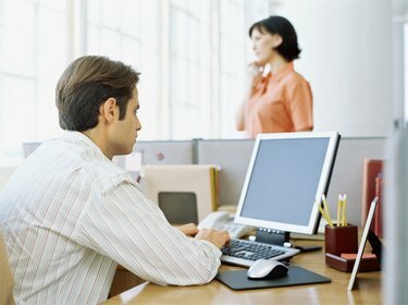 منظر خلفي لرجل أعمال يستخدم جهاز كمبيوتر في حجرة مكتب