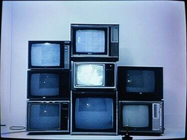 Joystick delante de una pila de televisores (imagen fija de vídeo)