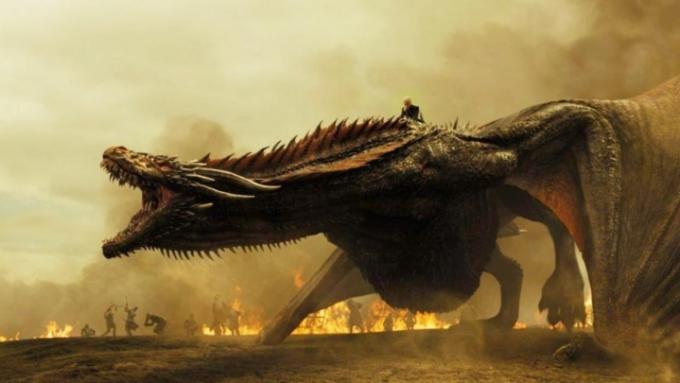 Drogon řvoucí s Daenerys, která na něm jela, a v pozadí hoří ohně.