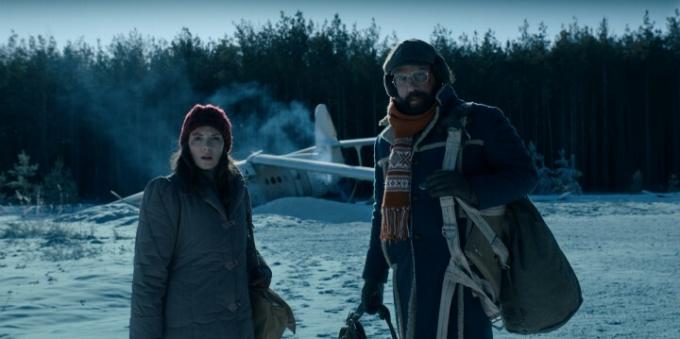 Winona Ryder en Brett Gelman staan ​​voor een neergestort vliegtuig in de sneeuw in een scène uit Stranger Things 4.