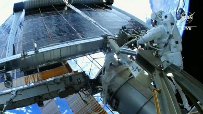 Astronauten Woody Hoburg tittar på när en ny utrullning av solpaneler utvecklas efter att han och andra NASA-rymdvandraren Stephen Bowen (utanför ram) framgångsrikt installerat den på rymdstationen.