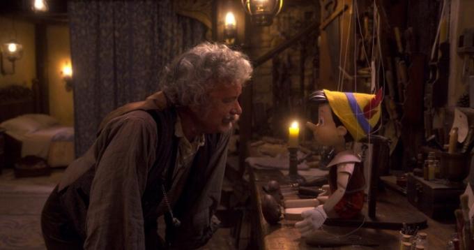 Tomas Hanksas, kaip Geppetto pasilenkia pasikalbėti su Pinokiu 2022 m. filmo scenoje.