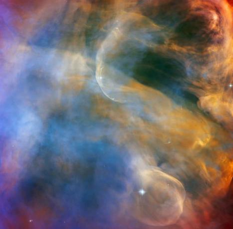 Ta nebesna oblačna pokrajina iz vesoljskega teleskopa NASAESA Hubble zajema barvito območje v Orionovi meglici, ki obdaja Herbig-Haro objekt HH 505. Objekti Herbig-Haro so svetleča območja, ki obkrožajo novorojene zvezde, ki nastanejo, ko zvezdni veter ali curki izbruha plina iz teh mladih zvezd, ki ustvarja udarne valove, ki trčijo v bližnji plin in prah na visoki hitrosti. V primeru HH 505 ti odtoki izvirajo iz zvezde IX Ori, ki leži na obrobju Orionove meglice približno 1000 svetlobnih let od Zemlje. Sami odtoki so vidni kot elegantno ukrivljene strukture na vrhu in dnu te slike. Njihova interakcija z obsežnim tokom plina in prahu iz jedra meglice jih popači v vijugaste krivulje.