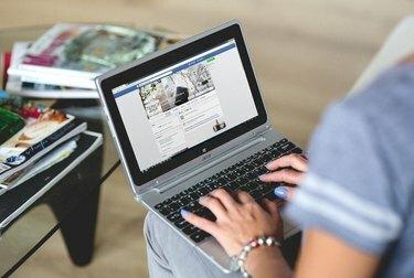 Mujer escribiendo en Facebook en la computadora portátil