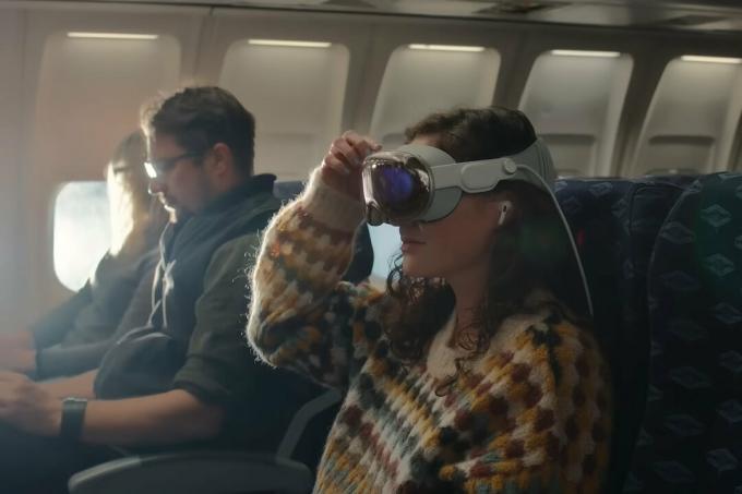 Oseba na letalskem letu nosi slušalke Apple Vision Pro.