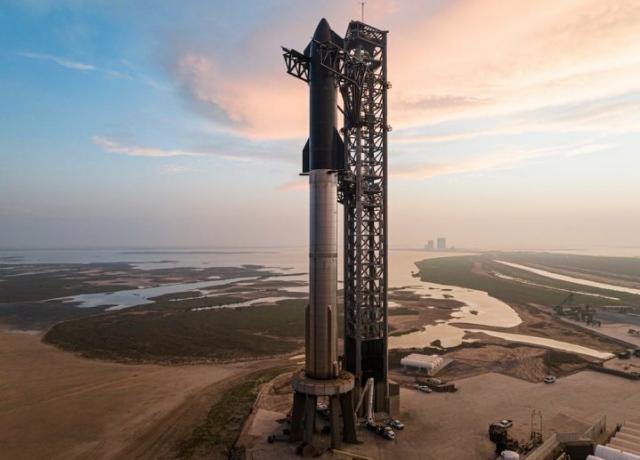 A Starship, composta pelo primeiro estágio Super Heavy e pela espaçonave Starship de estágio superior, na plataforma de lançamento nas instalações da SpaceX em Boca Chica, Texas.