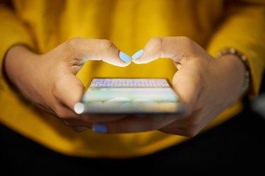 Mujer escribiendo mensaje de teléfono en la red social por la noche