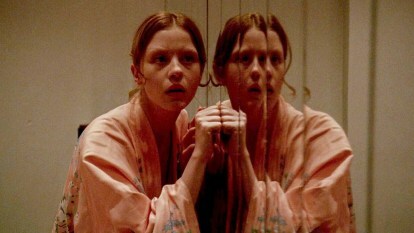 Dívka klepe na dveře zrcadla v roce 2018 Suspiria.