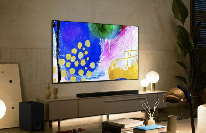 Smart TV LG B2 OLED 4K připevněná ke stěně nad zábavním centrem v obývacím pokoji.