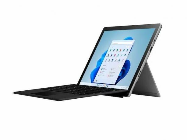 Un Microsoft Surface Pro 7+ in posizione verticale con una tastiera collegata su uno sfondo bianco.