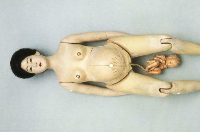 Gravid docka med baby på en navelsträng