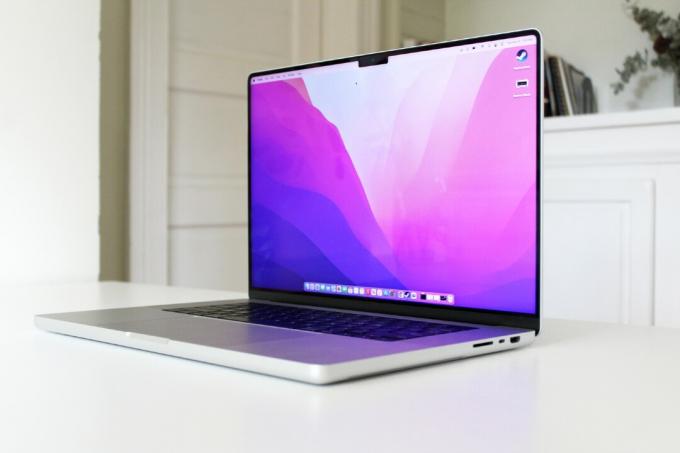 Il MacBook Pro 2021 con il coperchio aperto su un tavolo bianco.