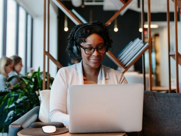 vrouw die werkt in een gedeelde ijverige werkruimte met laptop.