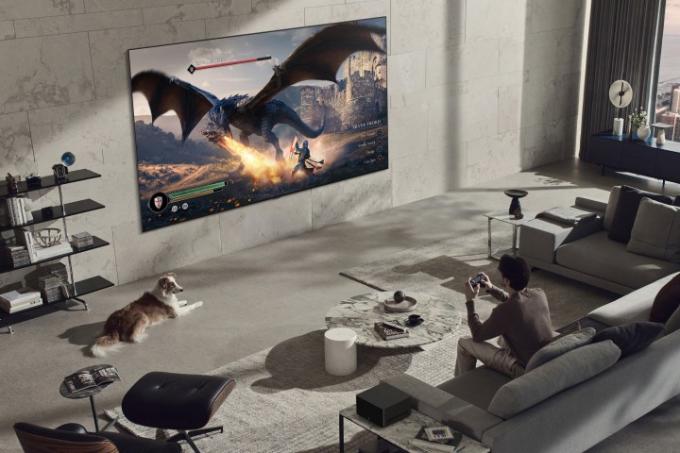 Seorang pria bermain video game di TV Signature OLED M3 4K LG 97 inci.