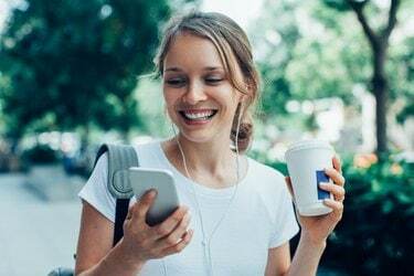 Nasmejana mlada ženska, ki ima video klic na prostem
