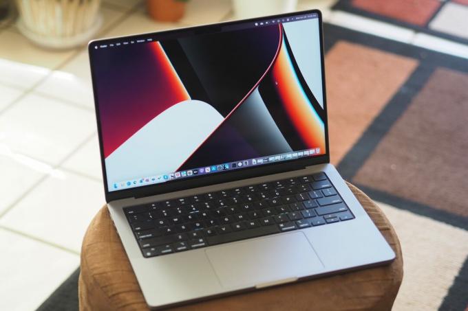 Apple MacBook Pro 14 leží otevřený na stole.