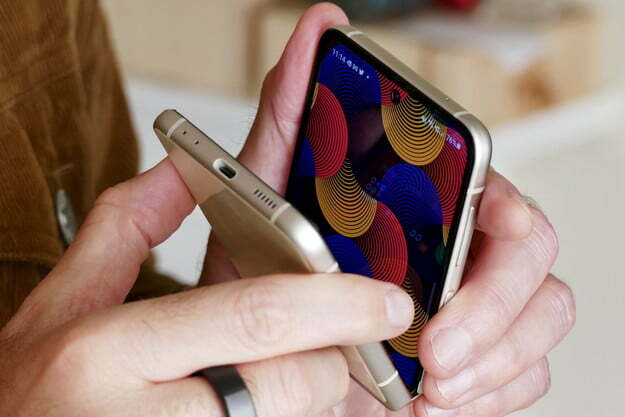 부분적으로 닫은 채 손에 쥐고 있는 골드 컬러의 Samsung Galaxy Z Flip 3.