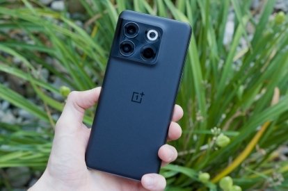 Turot OnePlus 10T zaļa auga priekšā.