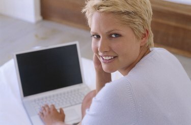 Portrét mladej ženy pracujúcej na notebooku