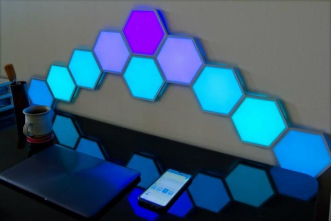 Svetlobne plošče Govee Hexa Glide, nameščene na steno za mizo.