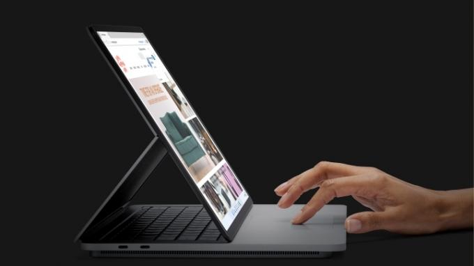 Käsi kasutas Surface Studio sülearvuti puuteplaati mustal taustal.