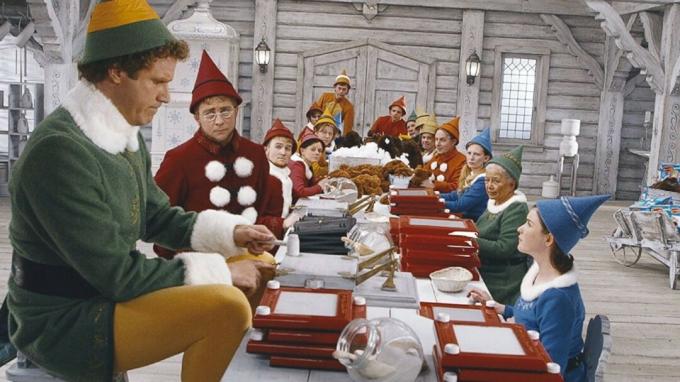 Buddy se tient à une table avec des elfes dans Elf.