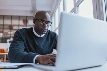 Jonge zakenman die aan zijn laptop werkt