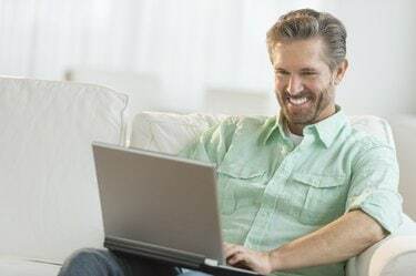 Щаслива людина за допомогою ноутбука на дивані