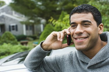 Man pratar i en mobiltelefon och ler