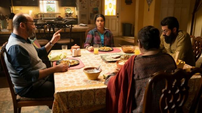 تجلس إيمان فيلاني وطاقم الممثلين الذين يلعبون دور عائلة كامالا خان حول مائدة العشاء في مشهد من فيلم السيدة مارفل.