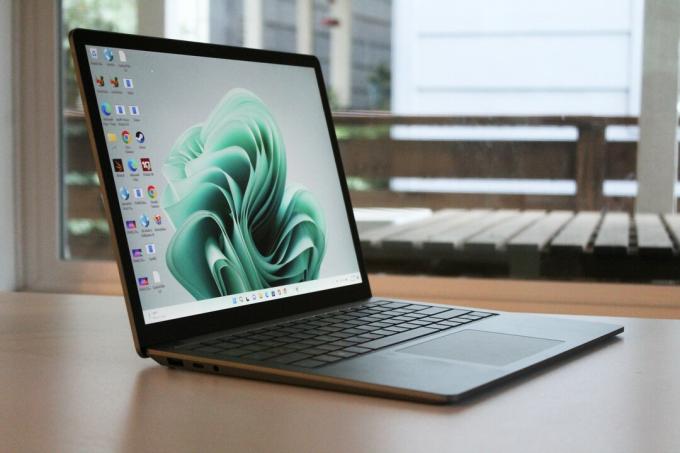 Surface Laptop 5 på et bord foran et vindue.