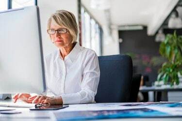 Mulher de negócios usando o computador na mesa do escritório