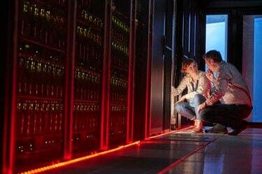 IT technici mluví na zářící panel v temné serverové místnosti