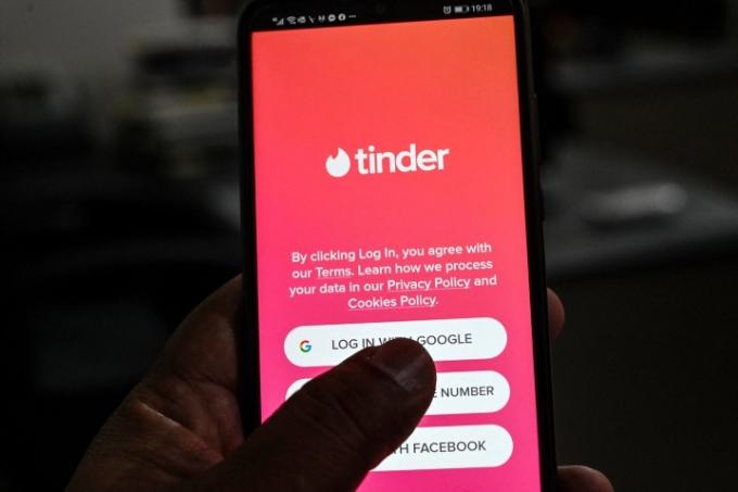 Пользователь проверяет приложение для знакомств Tinder на мобильном телефоне.