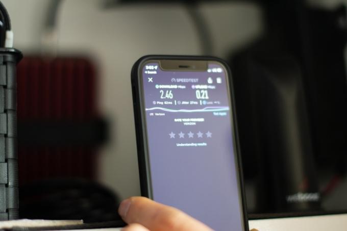 Bližnji posnetek pametnega telefona, ki prikazuje preizkus hitrosti pred omarico za avtodome