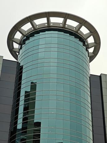 Foto ampliada de um edifício circular de vidro.