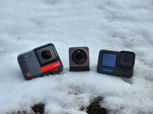 Το Insta360 One RS με το mod lens 360, DJI Action 2 και GoPro Hero 10 Black σε μια τράπεζα χιονιού.