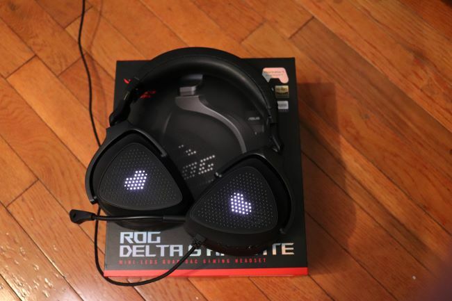 Le casque Asus ROG Delta S Animate repose sur son emballage avec des effets en forme de cœur sur l'écran extérieur.