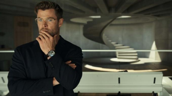 Chris Hemsworth는 Spiderhead의 한 장면에서 큰 유리창을 통해 응시합니다.