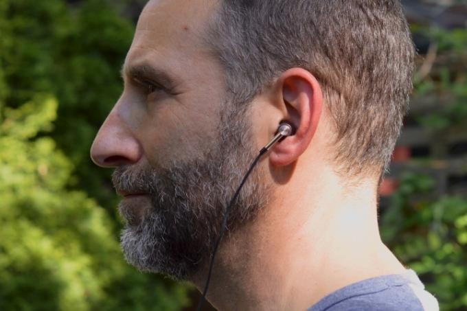 Moški, ki nosi ušesne monitorje 1More Triple Driver.