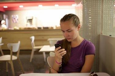 Flicka som läser e-post via telefon