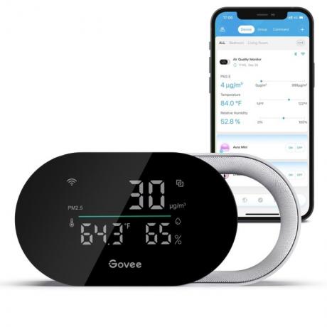 De Govee Smart Air Quality Monitor geplaatst voor een smartphone waarop de Govee-app wordt weergegeven.