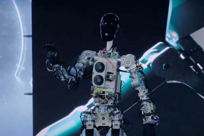 テスラ初のオプティマスプロトタイプロボット、バンブルシーが人間に手を振っている。