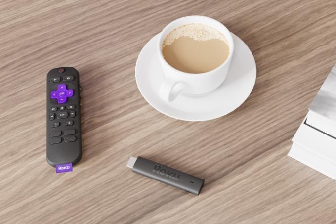 Roku Streaming Stick 4K och fjärrkontroll på ett bord med kaffe.