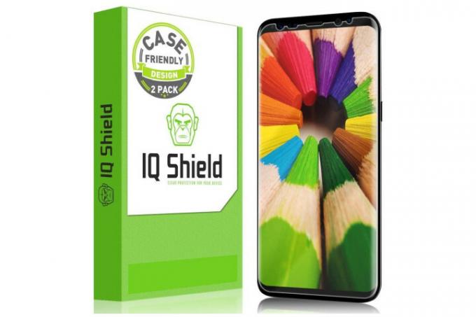 A képen a Samsung Galaxy S8 telefon látható IQ Shield kijelzővédő fóliával és a fehér és zöld dobozzal