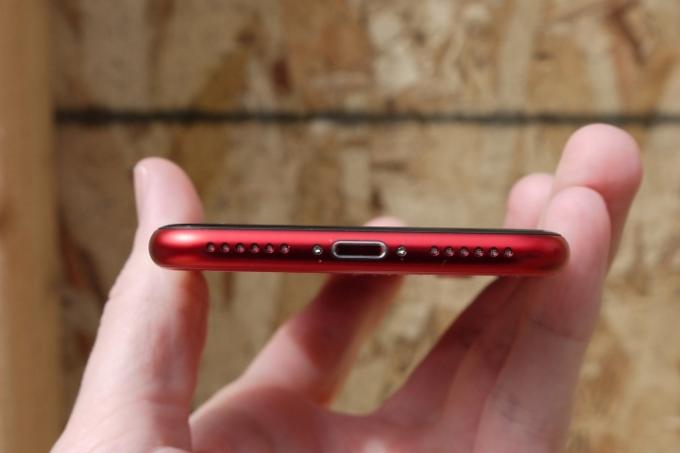 Le bas d’un iPhone SE rouge.