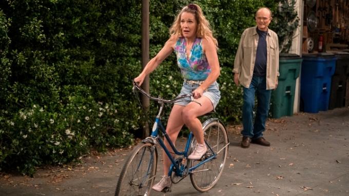 Sherri aus That '90s Show versucht Fahrrad zu fahren, während Red lächelnd zusieht.